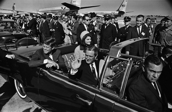22 Kasım 1963 günü Dallas'a gelen JFK ve yanında eşi Jacqueline ve önünde Texas valisi oturduğu halde havaalanından üstü açık arabayla ayrıldı. 1 saat sonra şehir merkezinde kkalabalığı selamlayarak seyir halindeyken biri boğazına diğeri kafasına isabet eden iki kurşunla hayatını kaybetti. 